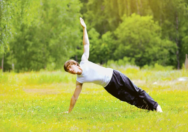 Yoga man doing exercise outdoors on the grass — Stock Photo, Image