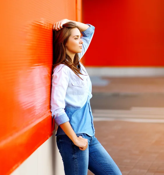 Mooie vrouw poseren in de buurt van heldere kleurrijke muur in de stedelijke st — Stockfoto