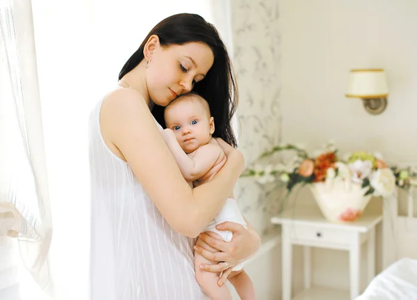Glückliche Mutter umarmt das Baby sanft — Stockfoto