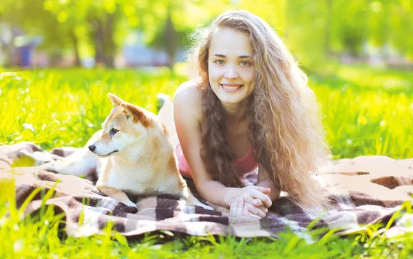 Счастливая девушка и собака отдыхают на траве — стоковое фото