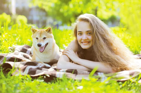 Menina feliz e cão se divertindo na grama — Fotografia de Stock