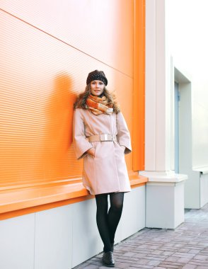 Palto ve şapka karşı renkli wal poz güzel kadın moda