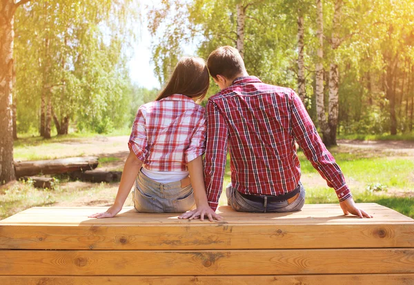 Pretty young modern couple in love resting outdoors in the park — Stock Photo, Image