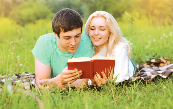 Νέοι όμορφο ζευγάρι μαζί, διαβάζοντας ένα βιβλίο μαζί για το γκρα — Φωτογραφία Αρχείου