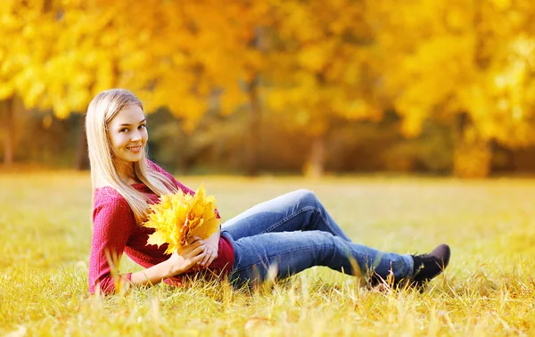 Portrait jolie jeune femme avec des feuilles d'érable jaune à l'extérieur en — Photo