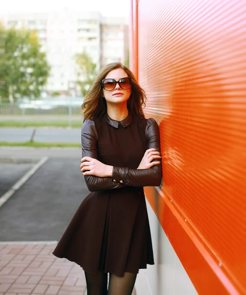 Hübsche Frau in Kleid und Sonnenbrille posiert in der Stadt — Stockfoto