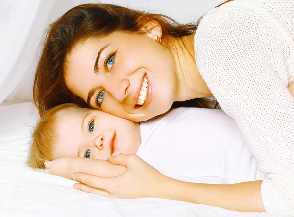 Happy cheerful portrait mother and baby in bed — Stock Photo, Image