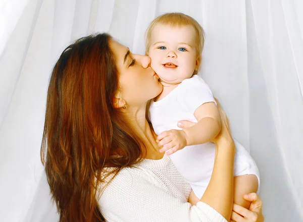 Portrait mother kissing baby on the bed home — Stock Photo, Image