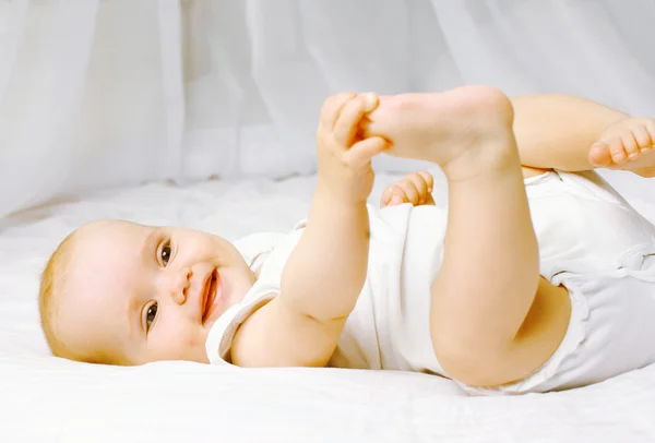 Lindo bebé sonriente en la cama —  Fotos de Stock