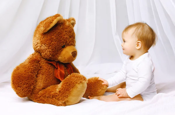 Lindo bebé jugando con osito de peluche en la cama casa —  Fotos de Stock