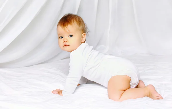 Bebê bonito rastejando na cama — Fotografia de Stock