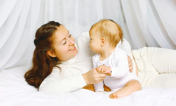 Happy mother with baby on the bed — Stock Photo, Image