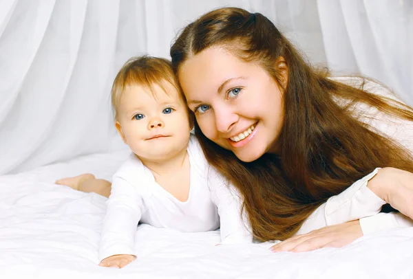 Retrato mãe feliz e bebê bonito na cama casa — Fotografia de Stock