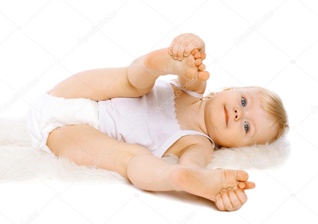 Calm cute little baby lying  playing on a white background
