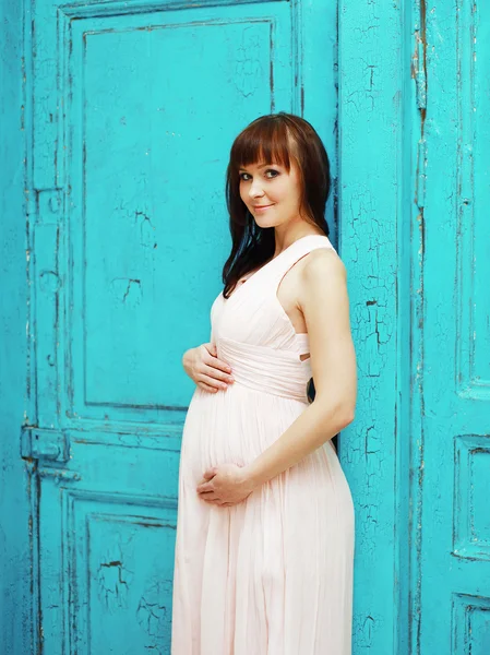 Krásná krásná těhotná žena v šatech proti barevné ba — Stock fotografie