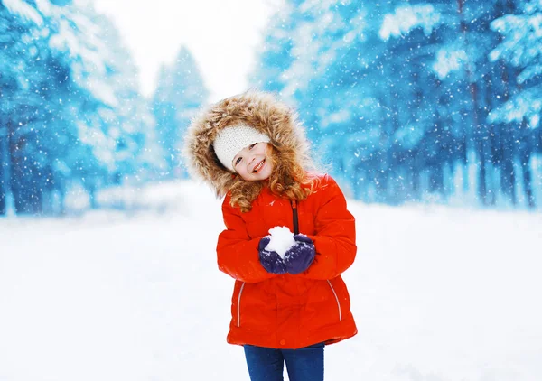 Glad positiv barn med snöboll har roligt utomhus i win — Stockfoto