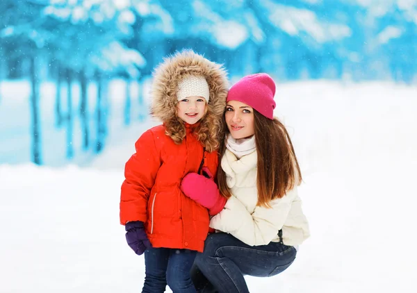 Gelukkig moeder met kind in besneeuwde winterdag — Stockfoto