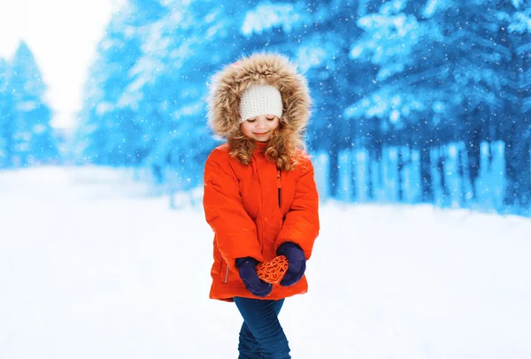 Little girl child with heart in hands outdoors winter — Stock Photo, Image