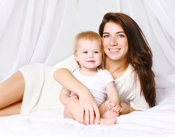 Happy mom and baby on the bed at home — Stock Photo, Image