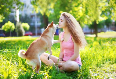Dog and owner girl outdoors in sunny park clipart