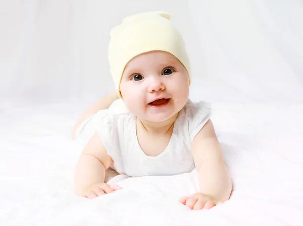 Bebê bonito em chapéu na cama em casa — Fotografia de Stock