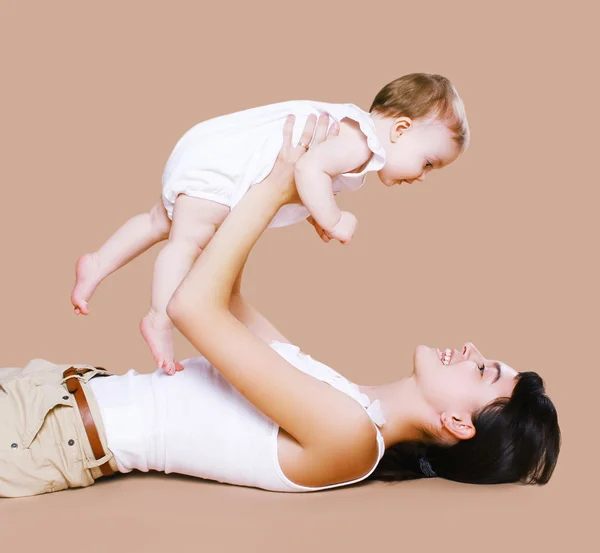 Madre mintiendo y divirtiéndose con el bebé — Foto de Stock