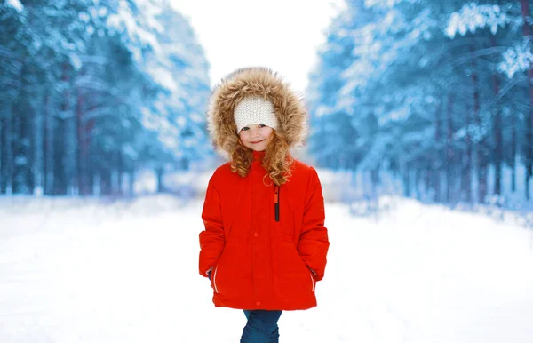 Szczęśliwe dziecko w czerwonej kurtce na zewnątrz w lesie zimą śnieżne — Zdjęcie stockowe
