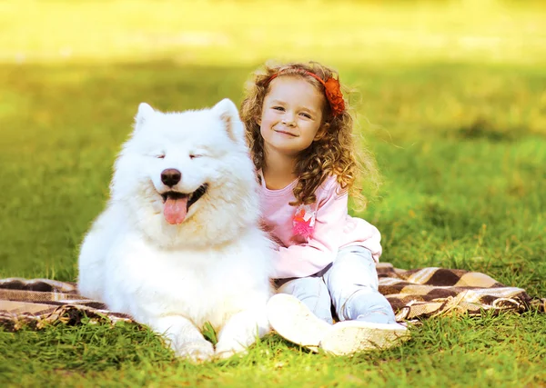Glückliches Kind und Hund, die auf dem Gras in warmen sonnigen Tag ruhen — Stockfoto