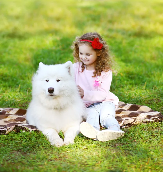 Child and dog resting on the grass in warm sunny day — Stock Photo, Image