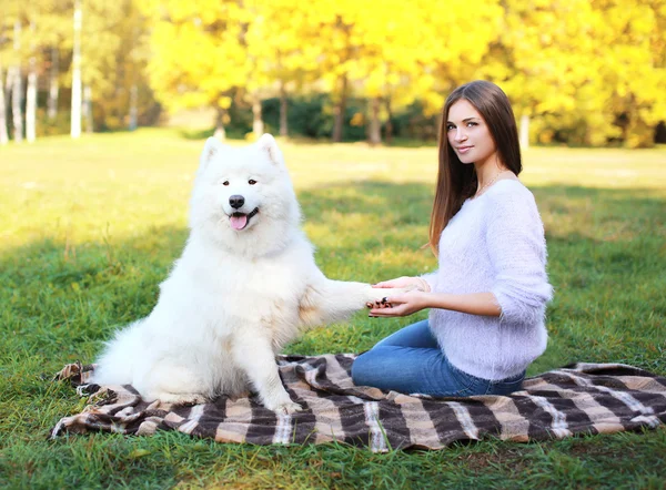 Beautiful woman and dog on the plaid outdoors in warm sunny day — Stock Photo, Image