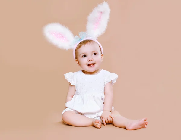 魅力的な赤ちゃんの衣装を着て座っているイースターのウサギ ストック画像