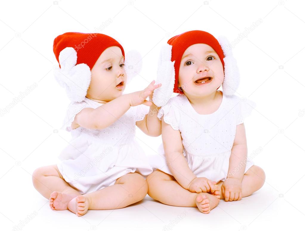 Two twins baby in hats playing
