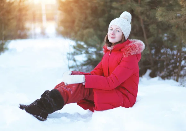 Chica bonita sentada en la nieve, clima soleado de invierno —  Fotos de Stock