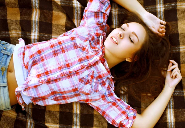 Pretty sensual young girl lying on the plaid outdoors, top view — Stock Photo, Image