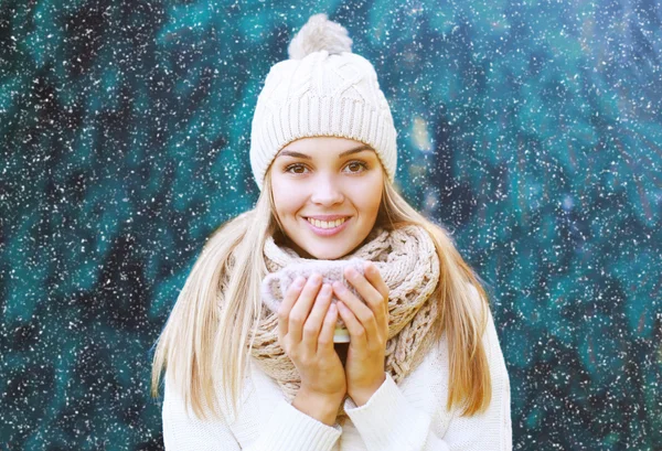 Femme heureuse en chapeau avec tasse à l'extérieur contre l'arbre de Noël — Photo