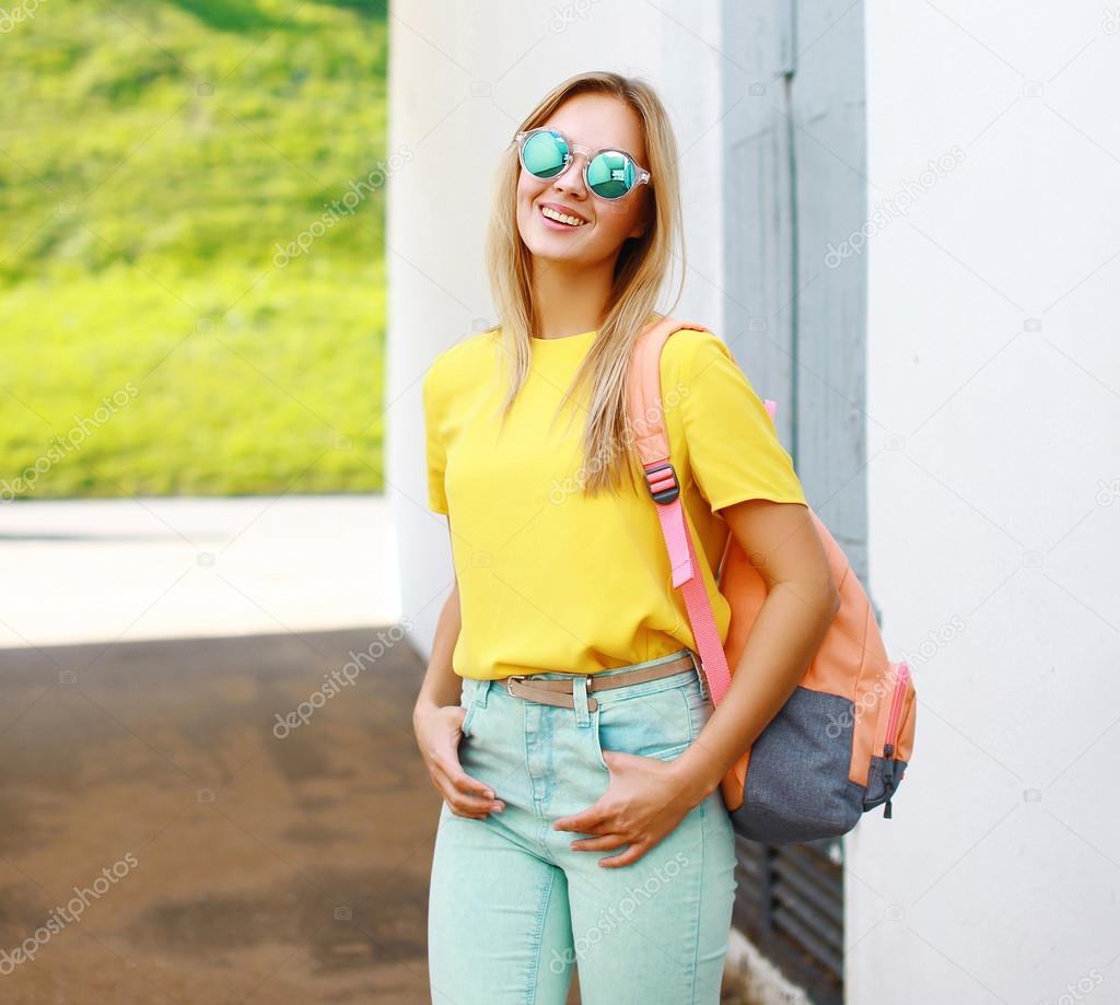 Fashion pretty cool girl in sunglasses with backpack outdoors