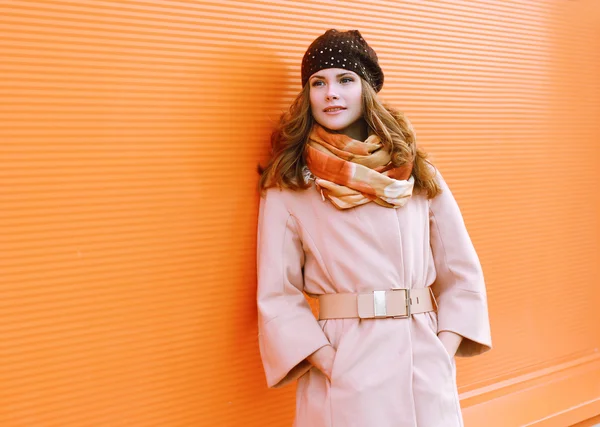 Mujer bonita en abrigo posando contra la pared colorida — Foto de Stock