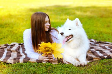 Mutlu güzel kadın portre ve beyaz Samoyed köpek dışarı eğleniyor