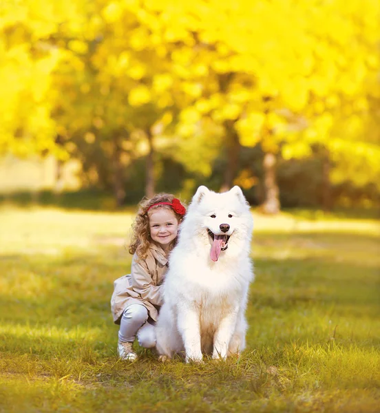 Happy positive child and dog having fun outdoors in warm sunny a — Stock Photo, Image