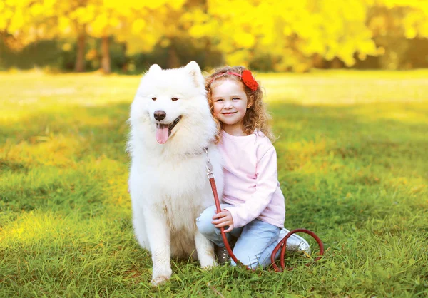 Happy little girl and dog having fun outdoors — Stock Photo, Image