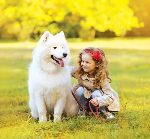 Positive child and dog having fun outdoors in the park — Stock Photo, Image