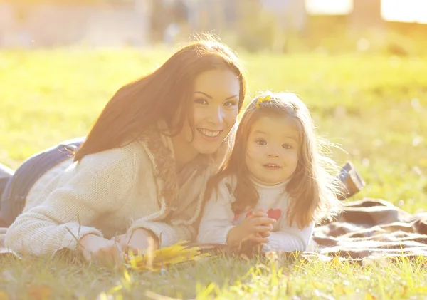 Anne ve çocuk gülümseyen güneşli bir sonbahar günde eğleniyor — Stok fotoğraf