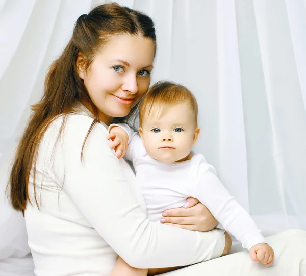 Portrait happy mother and baby on the bed at home — Stock Photo, Image