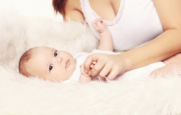 Niedliche Baby und Mutter auf dem Bett zu Hause liegen — Stockfoto