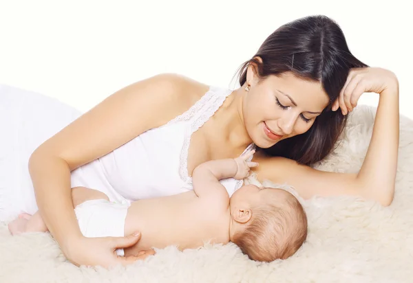 Happy smiling mother and baby lying on the bed at home, family c — Stock Photo, Image