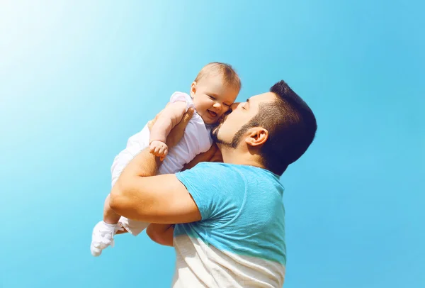 Семейное фото счастливого отца, целующего ребенка на свежем воздухе — стоковое фото