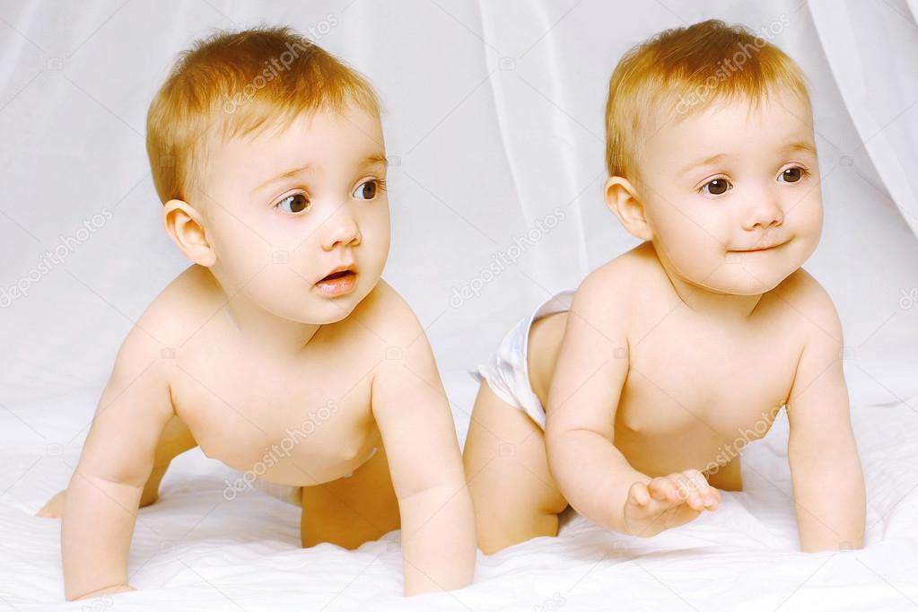 Two cute twins baby on the bed at home
