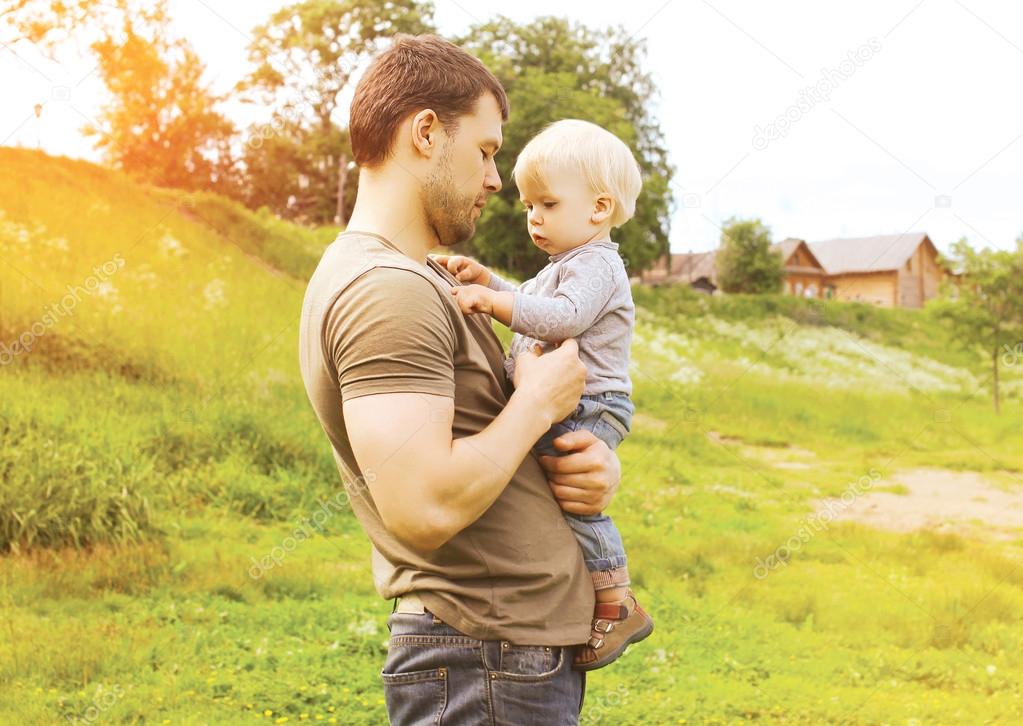 Father and child together outdoors in summer warm day countrysid