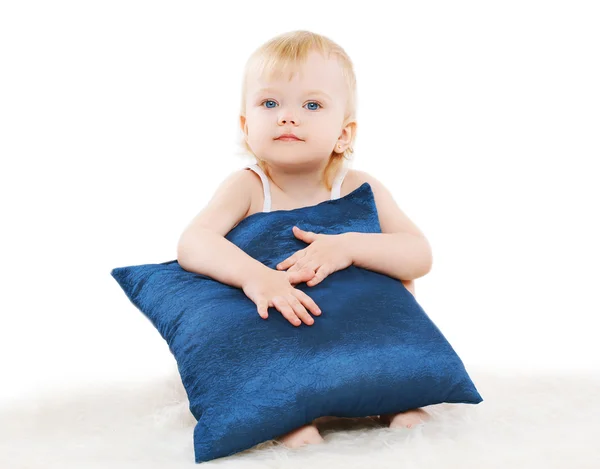Bambino carino con un cuscino su uno sfondo bianco — Foto Stock