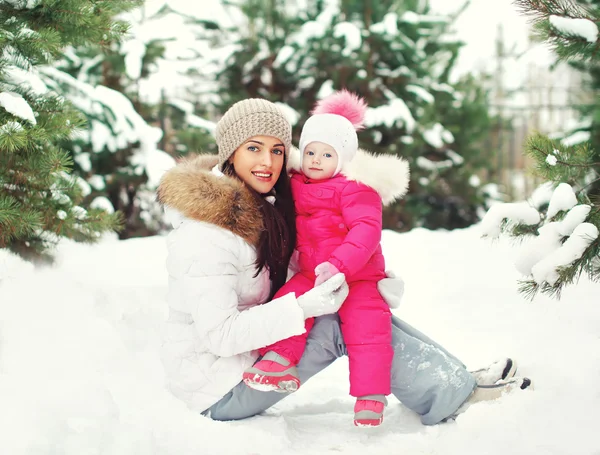 Gelukkig moeder en kind plezier buiten in de buurt van kerstbomen — Stockfoto